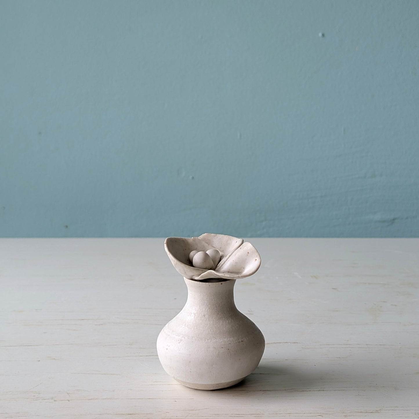 Small ceramic bottle with flower shaped lid