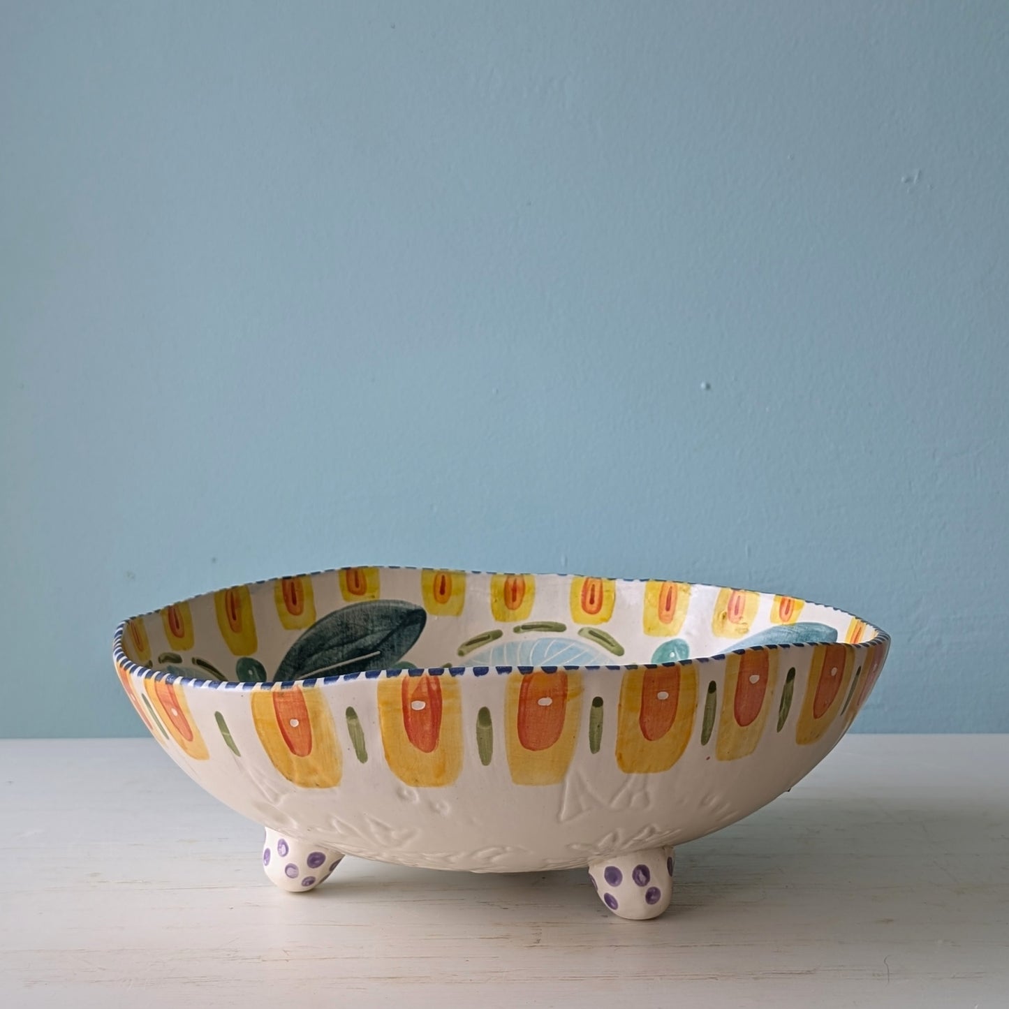Decorative ceramic bowl with colorful design on a light blue background