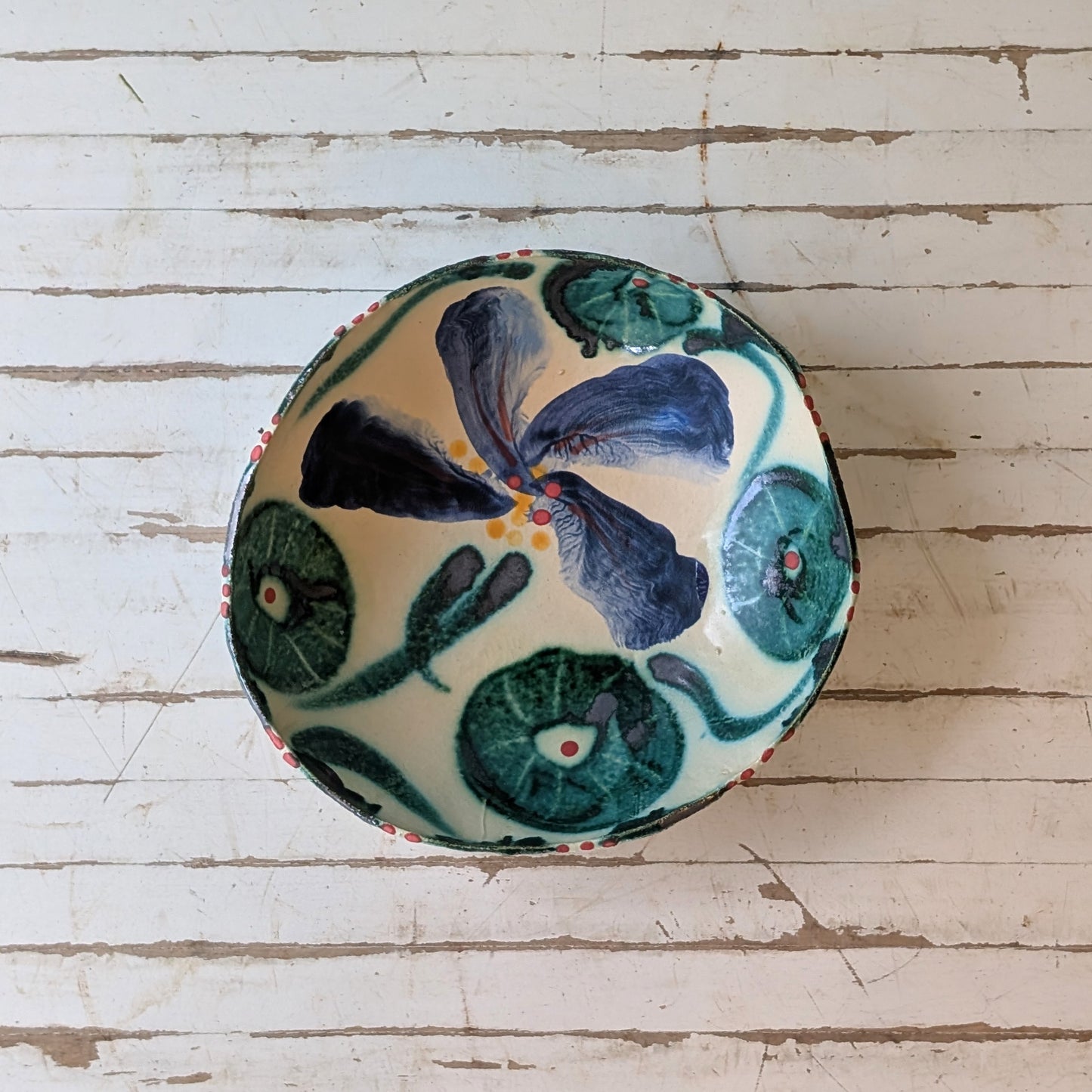 Round ceramic bowl with floral design on a wooden surface
