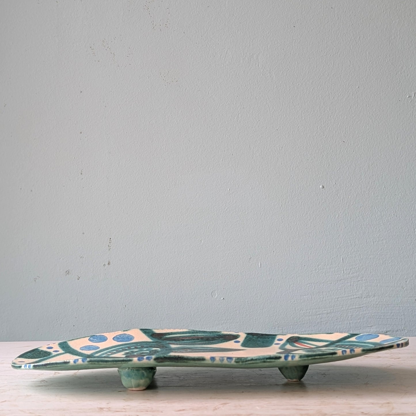 Ceramic platter with leaf pattern on a light blue background