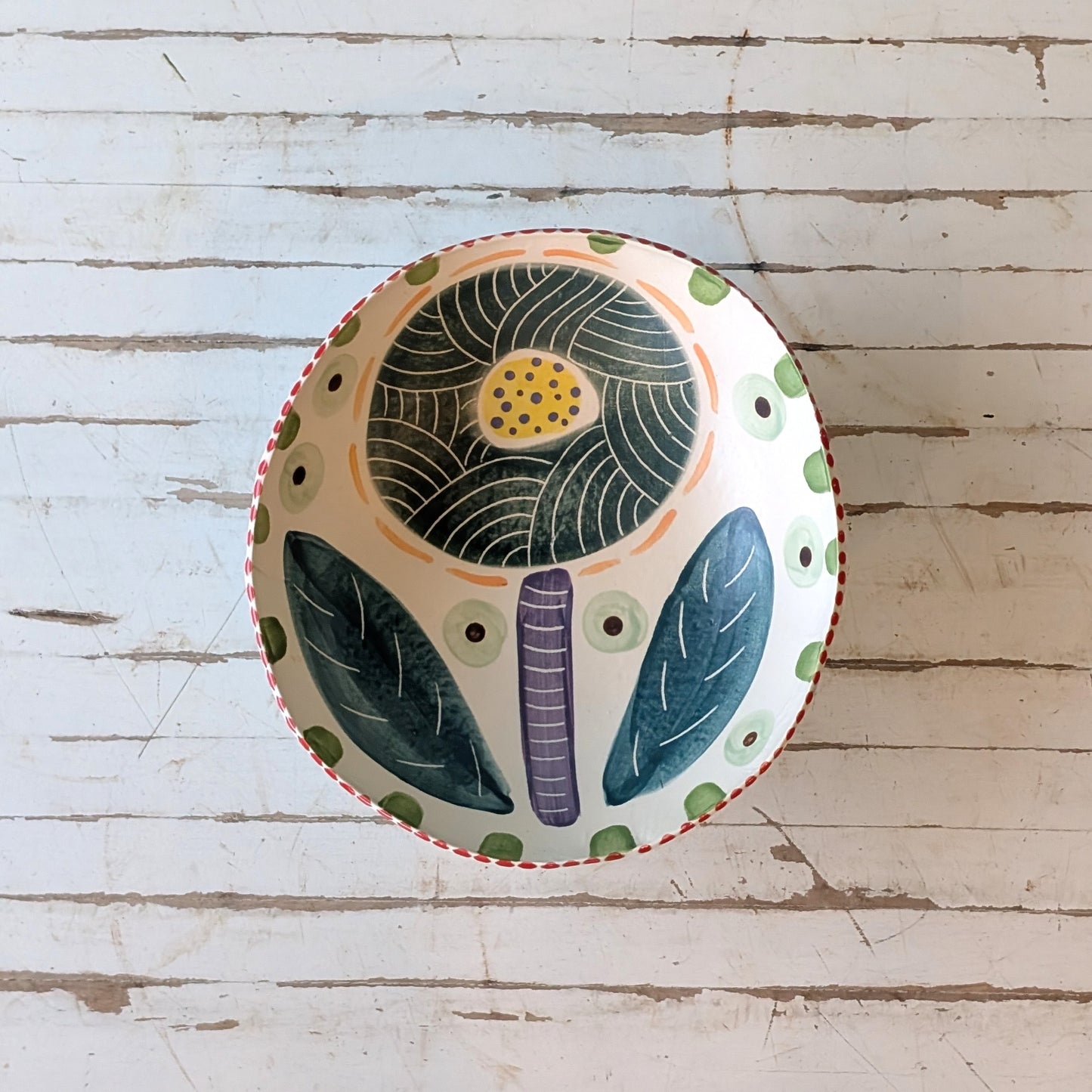 Decorative bowl with floral design on a wooden surface
