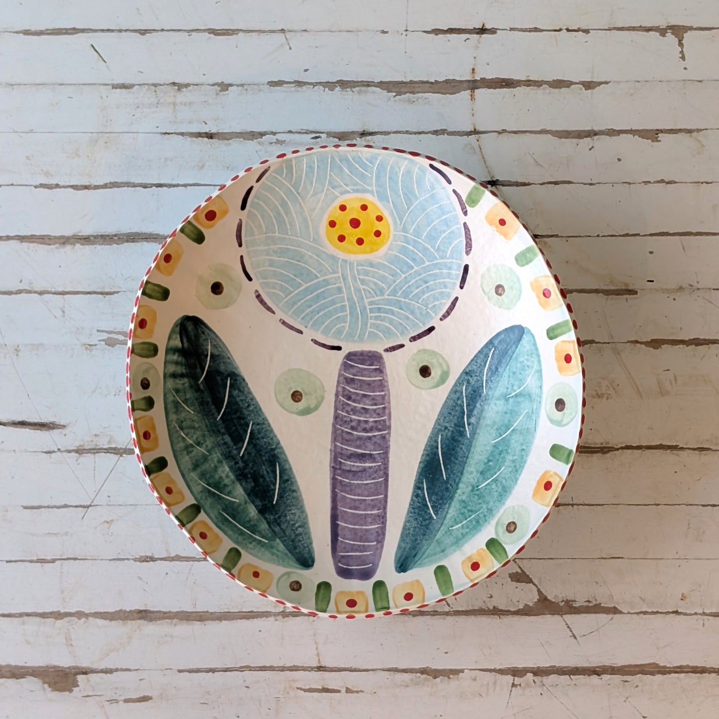 Decorative ceramic plate with floral design on a wooden surface