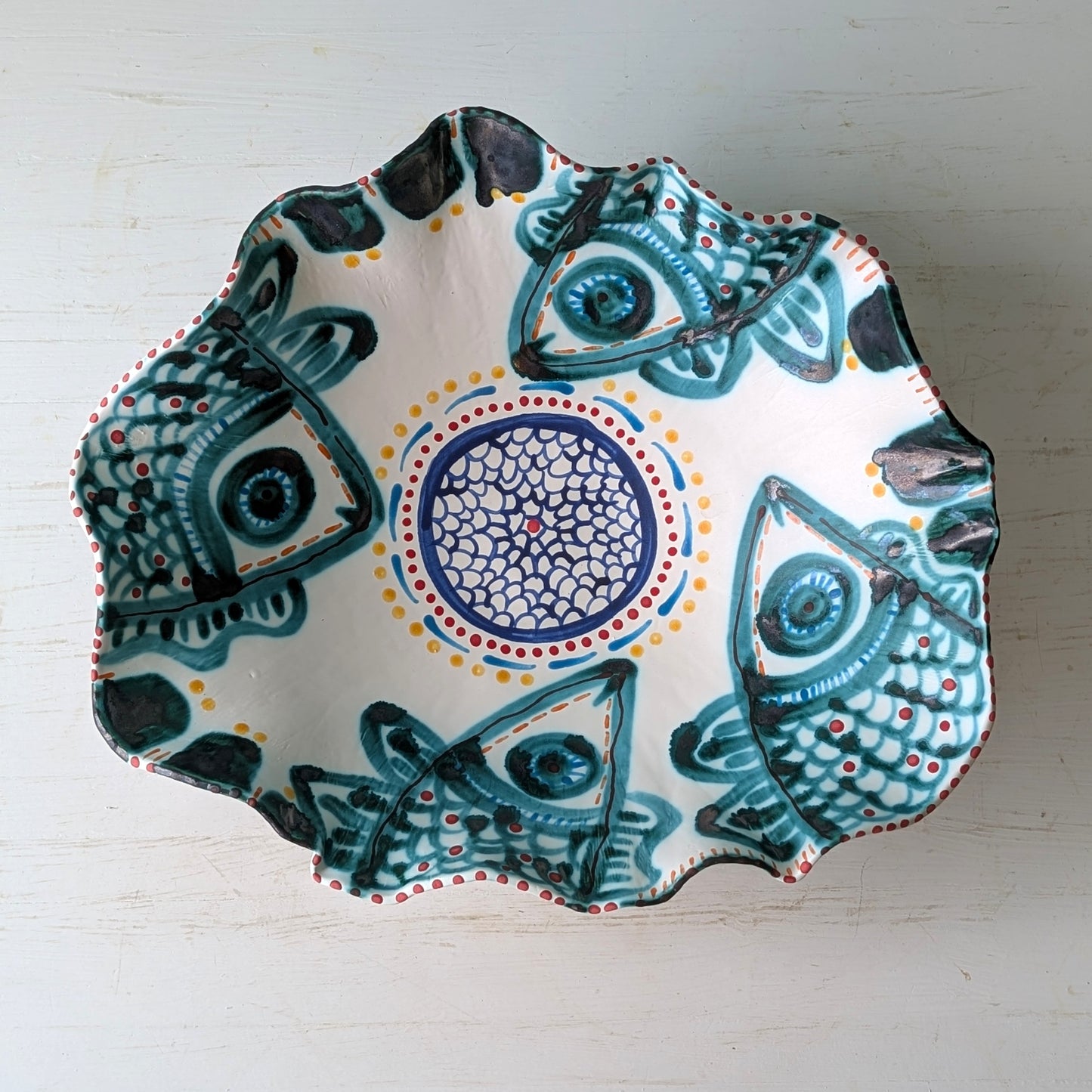 Decorative ceramic bowl with fish design on a white background