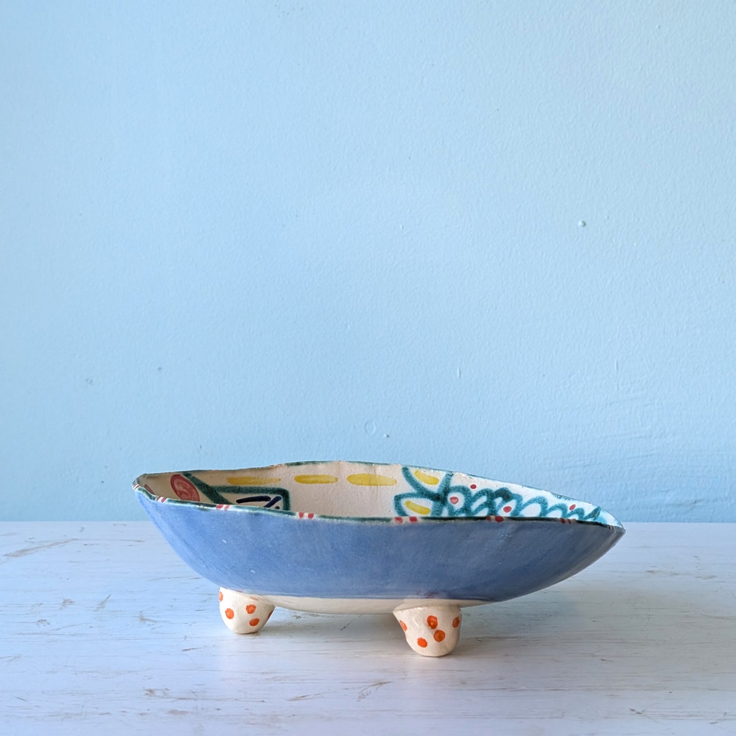 Ceramic bowl with colorful design on a light blue background