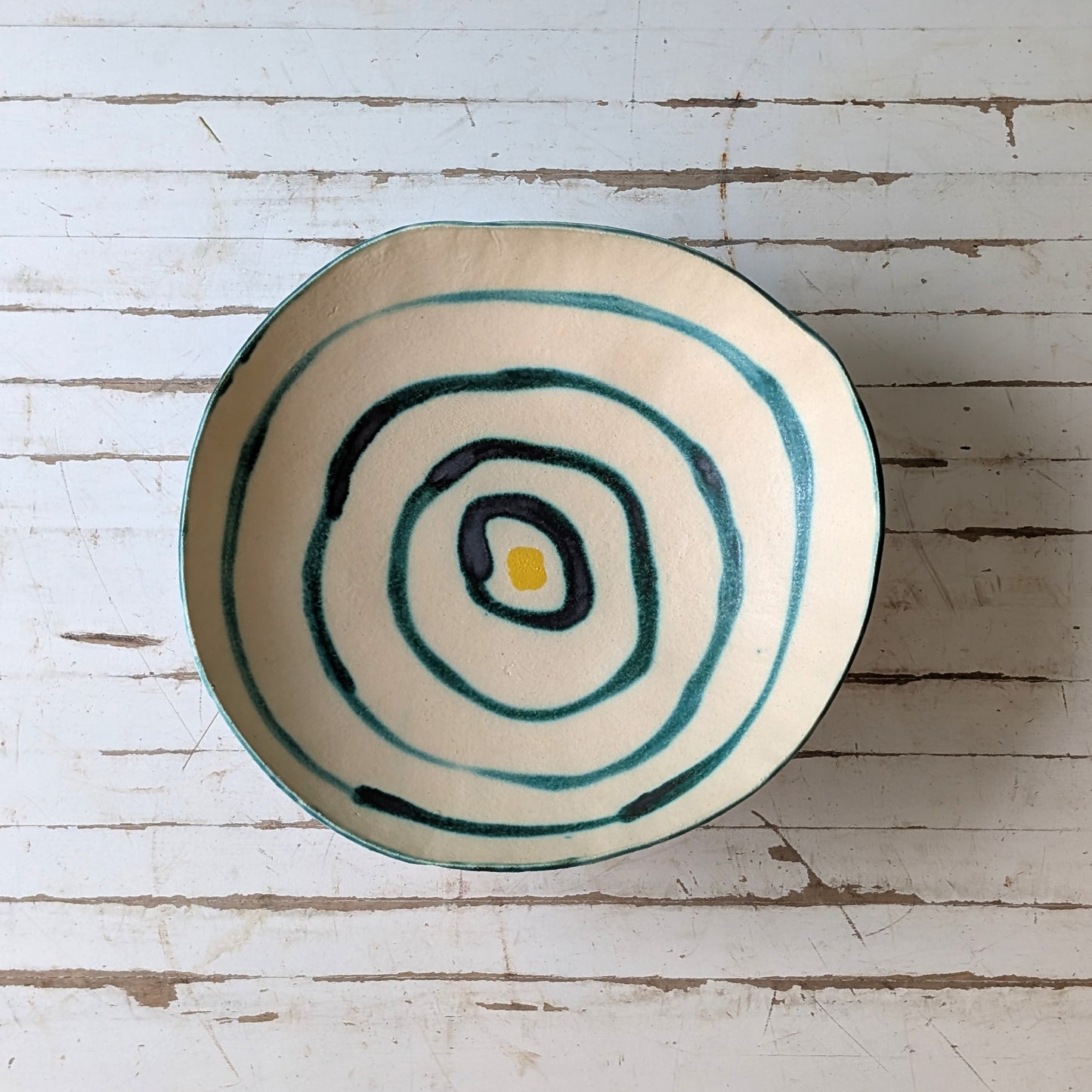 Ceramic bowl with concentric circle design on a wooden surface