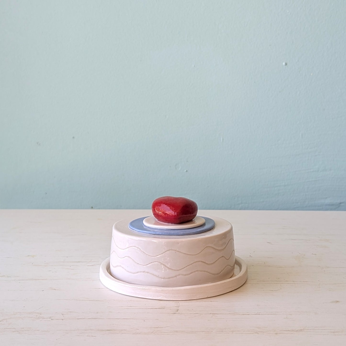 Round ceramic butter dish with red heart on top