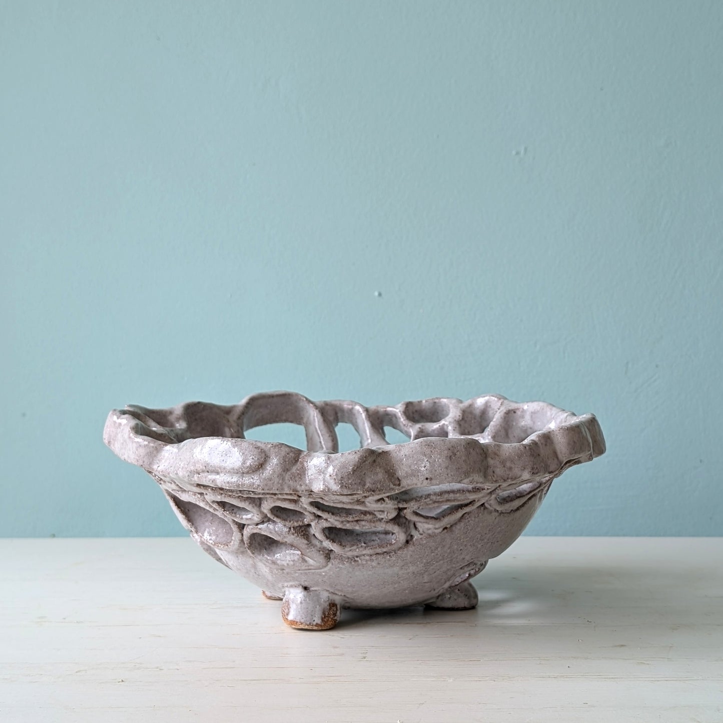 Decorative ceramic bowl on a light surface with a light blue background