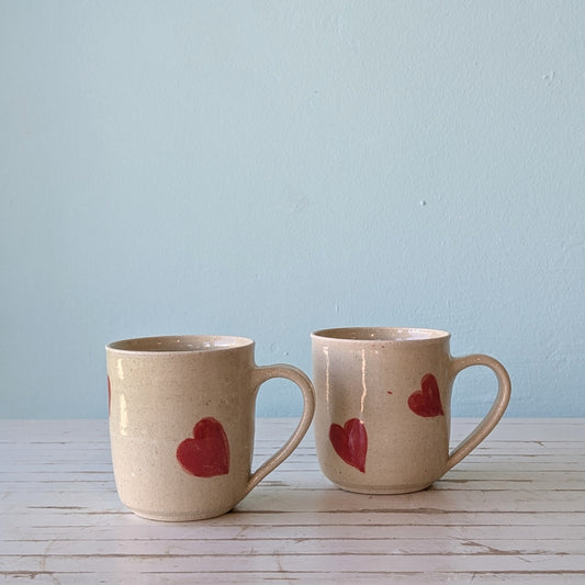 two ceramic mugs with pink heart pattern