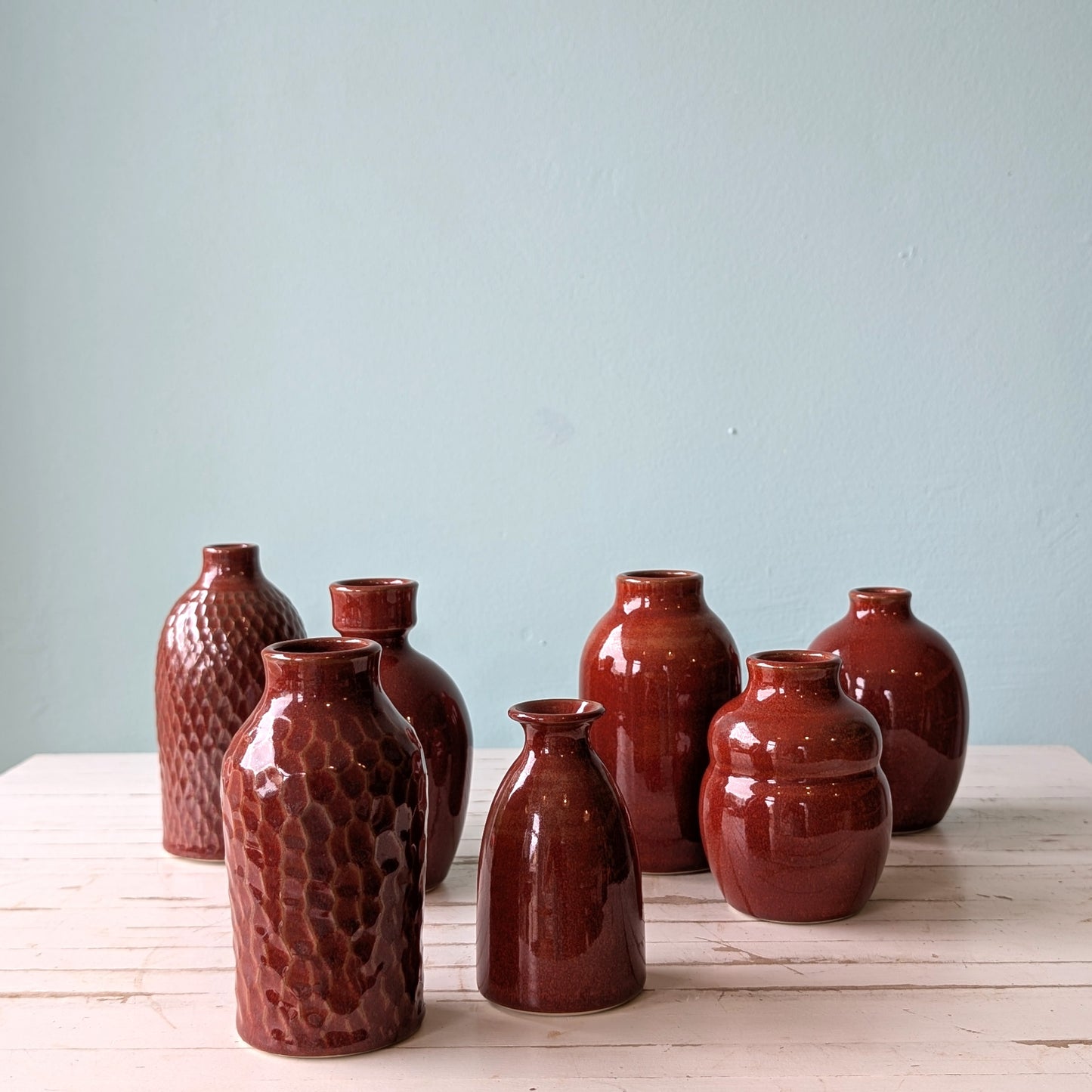 Collection of 7 ceramic bud vases with red ember glaze by Asahi So