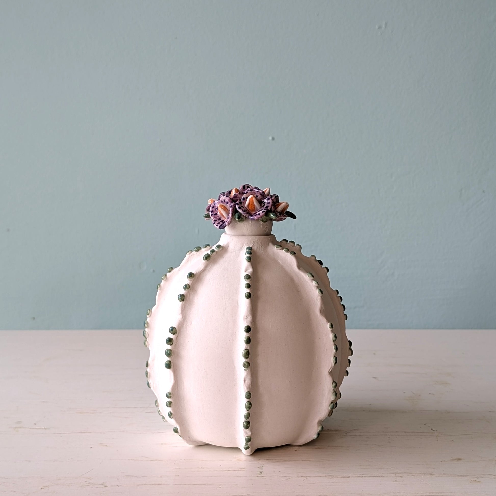 Decorative porcelain vase with floral top on a light blue background
