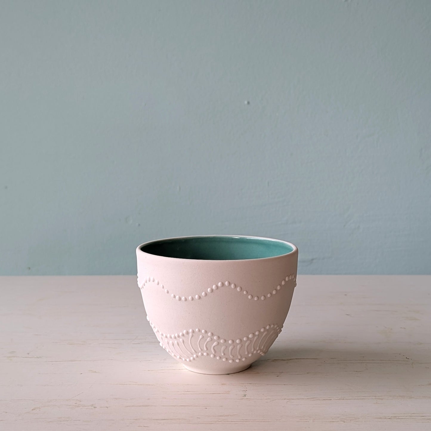 Ceramic bowl with textured design on a light surface against a plain background