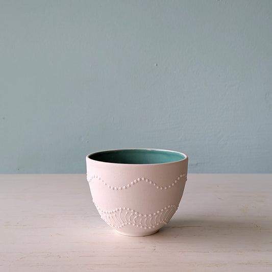 Ceramic bowl with textured design on a light surface against a plain background