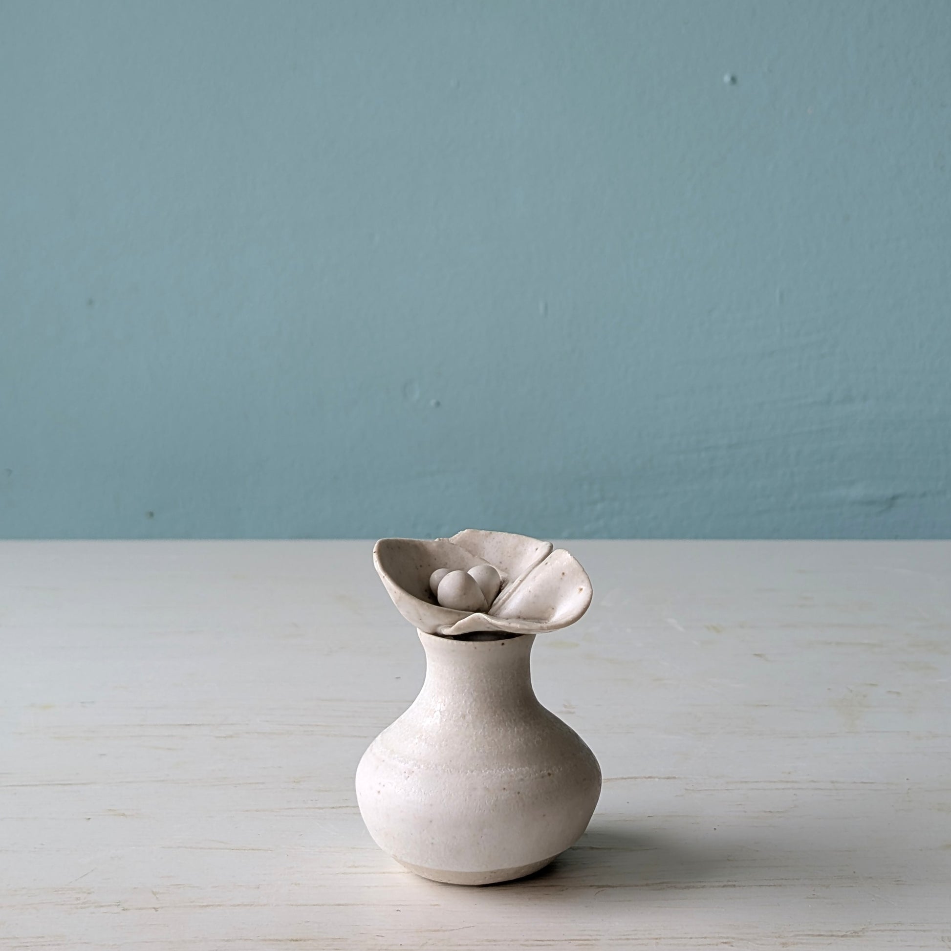 Small ceramic bottle with flower shaped lid