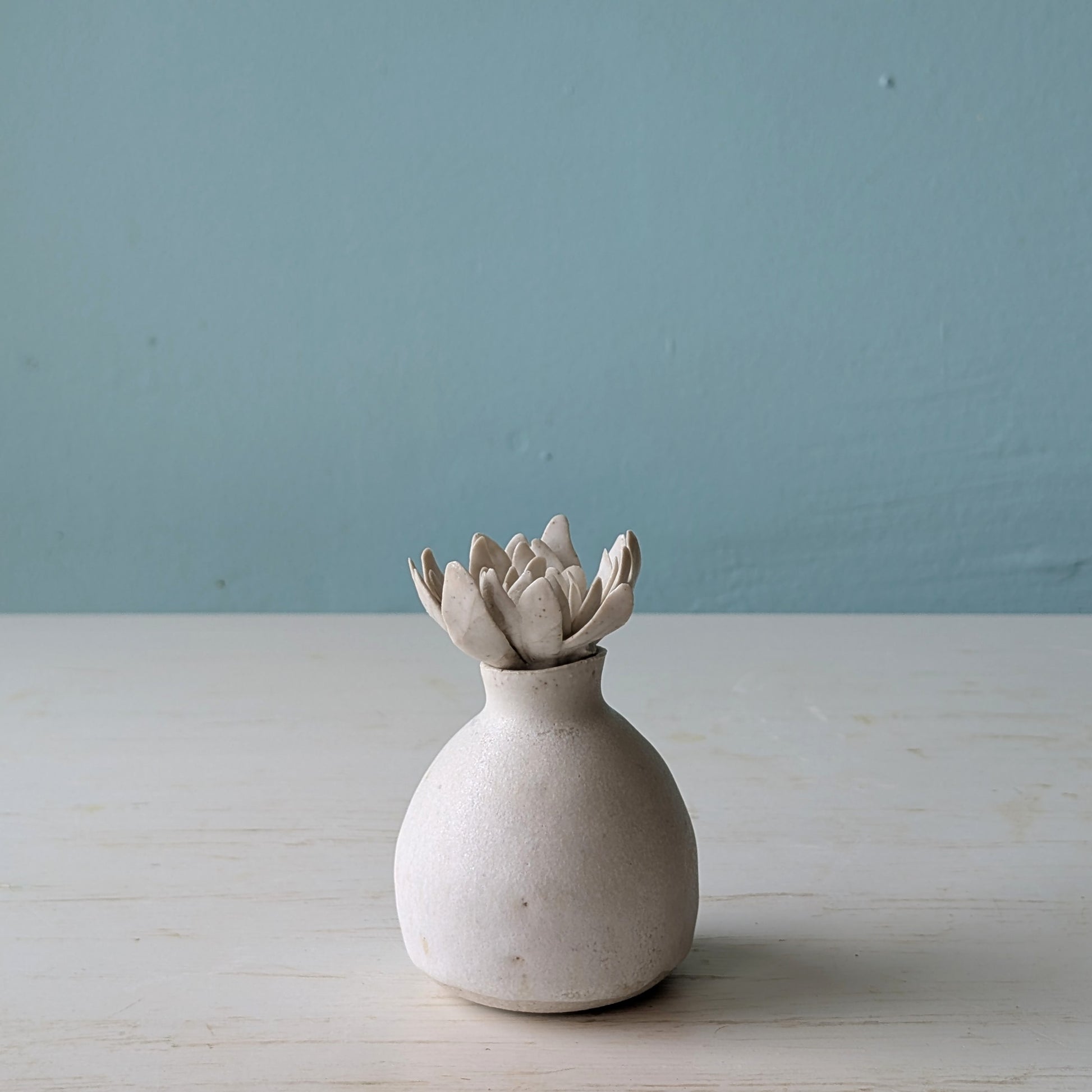 Small ceramic bottle with flower shaped lid