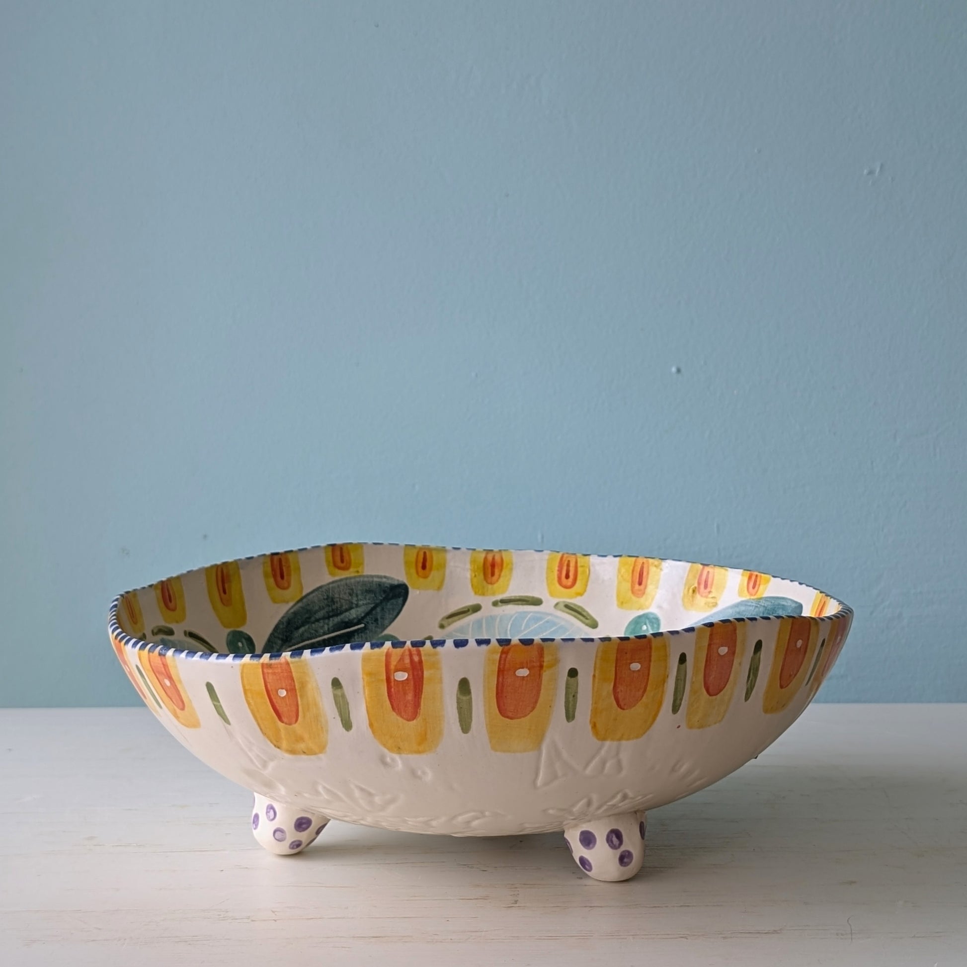 Decorative ceramic bowl with colorful design on a light blue background