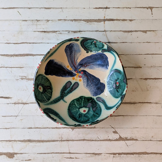 Round ceramic bowl with floral design on a wooden surface