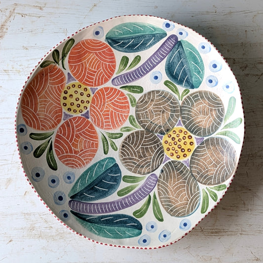 Decorative ceramic plate with colorful abstract patterns on a wooden surface