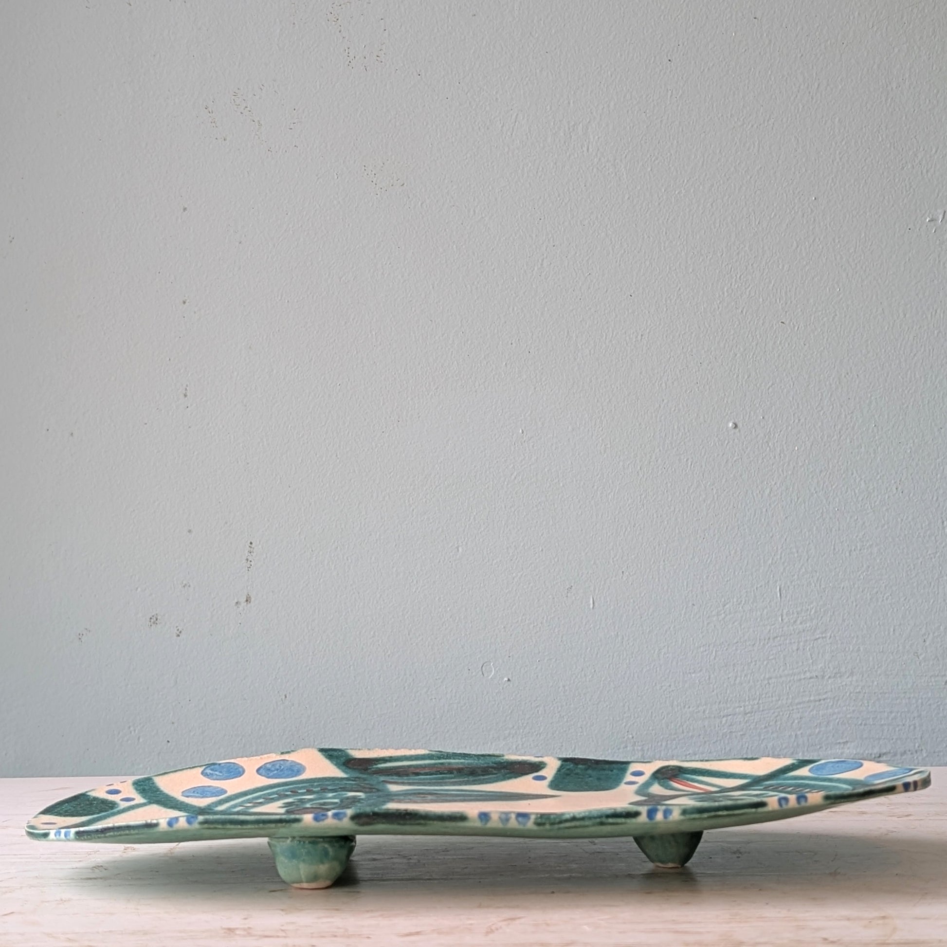 Ceramic platter with leaf pattern on a light blue background