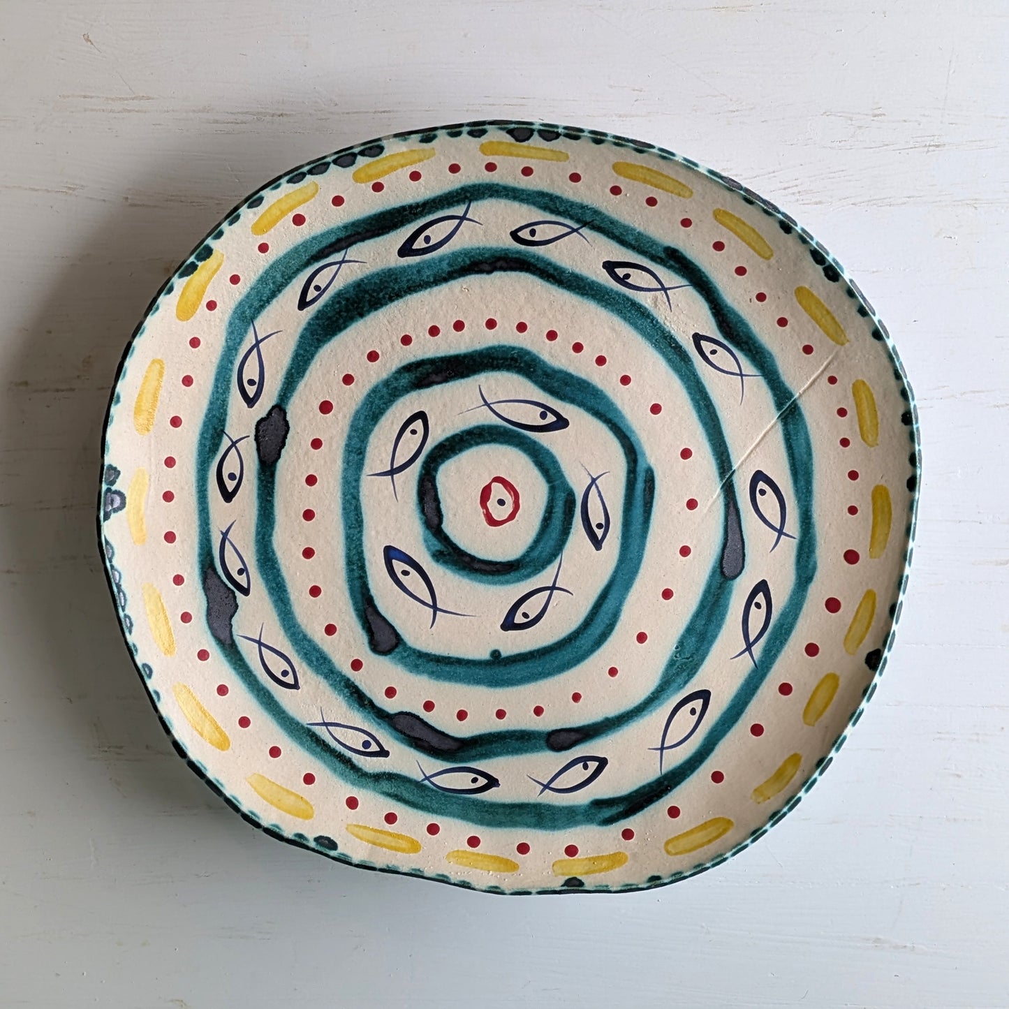 Ceramic platter with fish pattern on a white background
