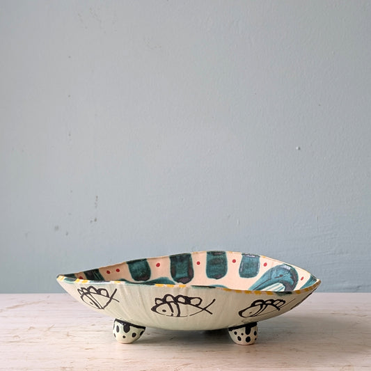 Ceramic bowl with decorative patterns on a light wooden surface and light blue background
