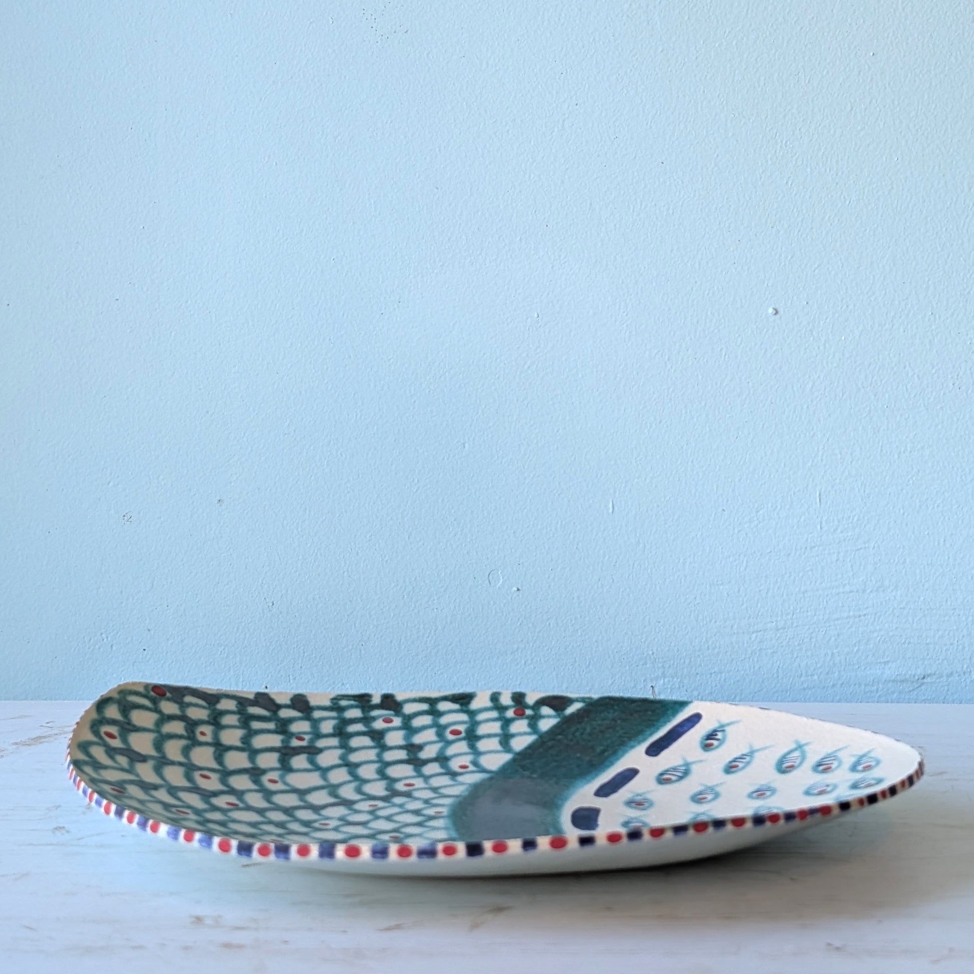 Ceramic platter with a fish pattern on a light blue background