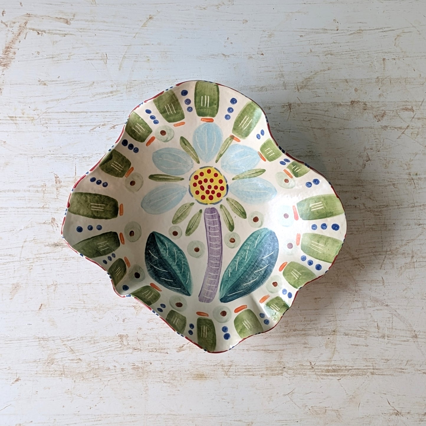 Decorative ceramic bowl with floral design on a light wooden surface