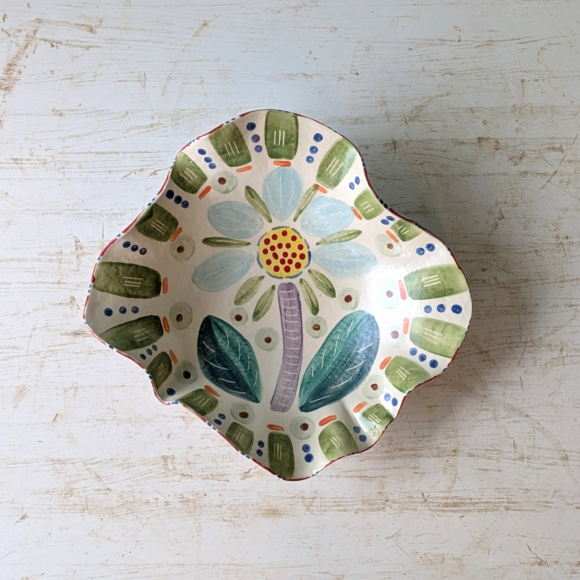 Decorative ceramic bowl with floral design on a light wooden surface