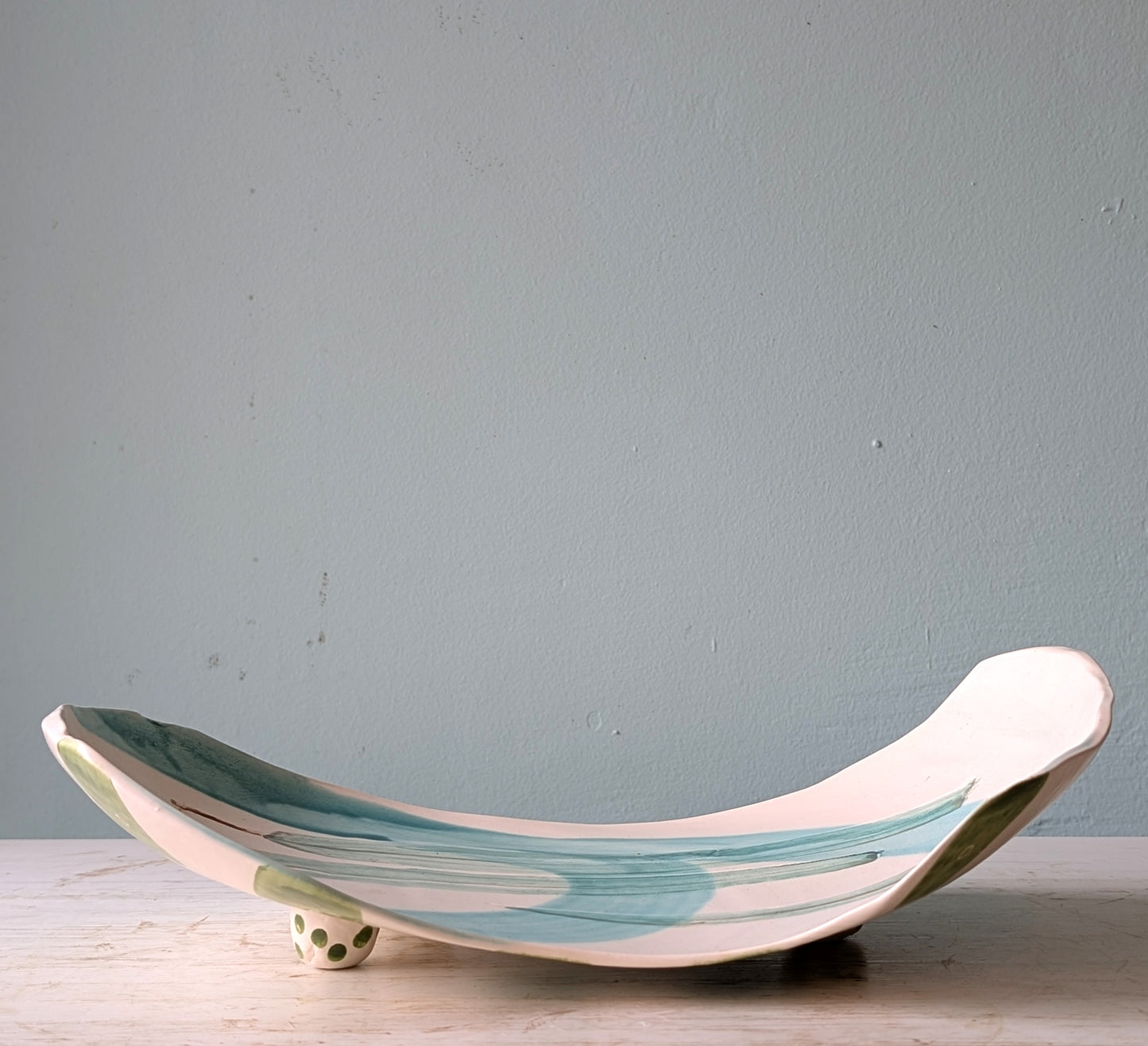 Ceramic platter with wavy design on a light blue background