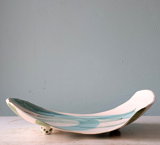 Ceramic platter with wavy design on a light blue background