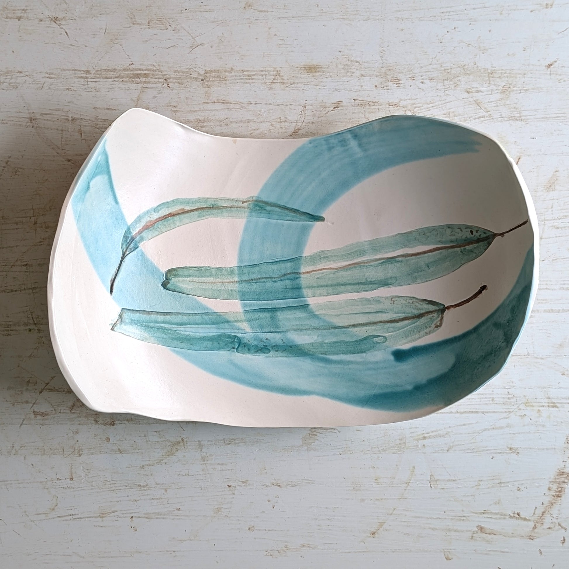 Decorative platter with green leaf design on a light background