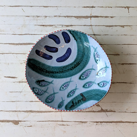 Ceramic bowl with fish pattern on a wooden surface