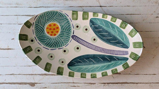 Decorative ceramic plate with floral design on a wooden surface