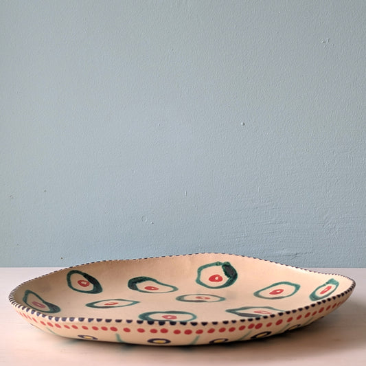 Ceramic platter with colorful patterns on a light blue background