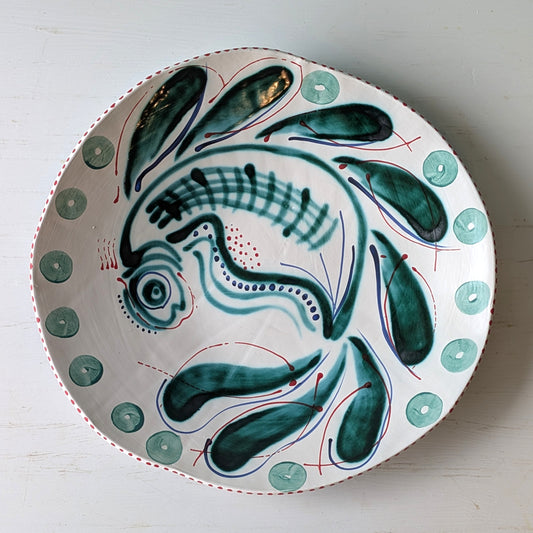 White ceramic platter with green fish pattern on white background