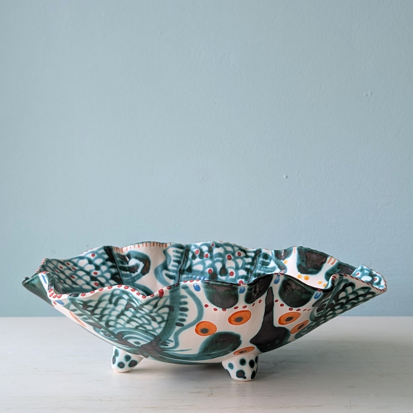 Decorative ceramic bowl with a colorful pattern on a light blue background