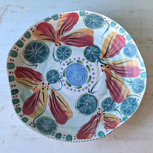 Decorative bowl with colorful floral design on a light wooden surface