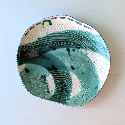 Decorative ceramic platter with a unique design on a light blue background