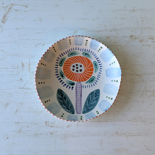 Decorative ceramic bowl with floral design on a light wooden surface