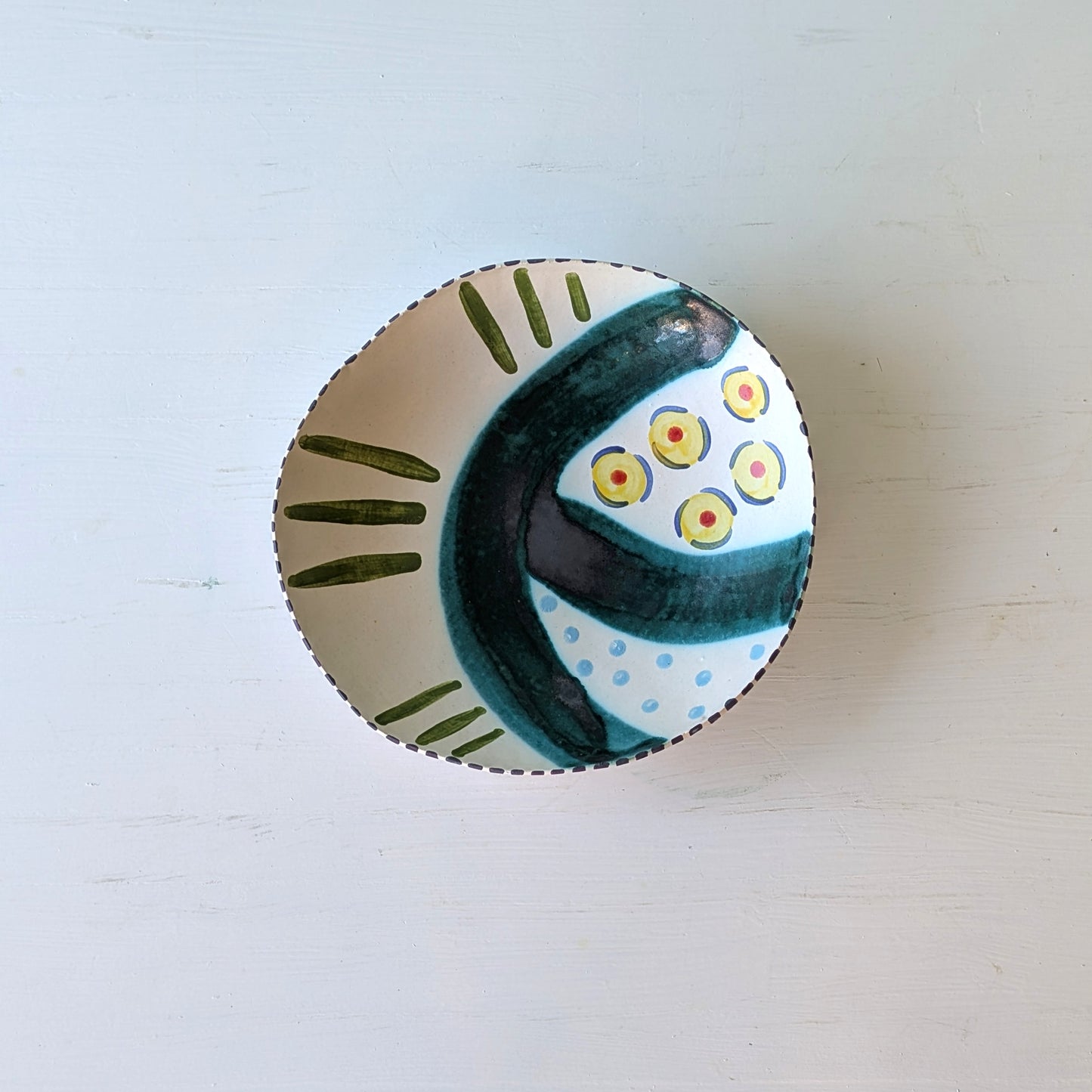 Ceramic bowl with decorative design on a light wooden surface
