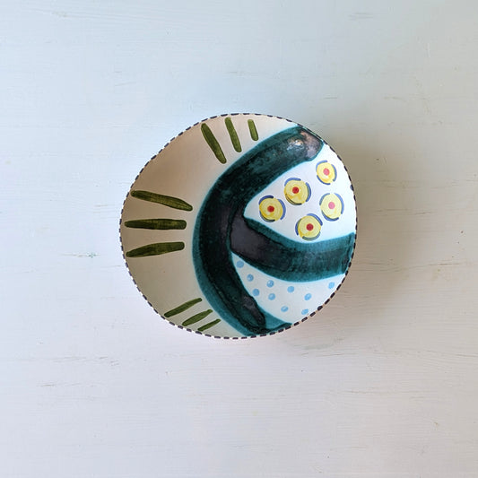 Ceramic bowl with decorative design on a light wooden surface