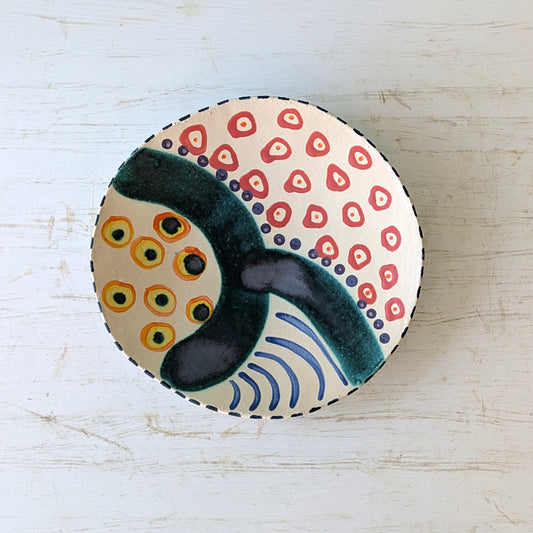 Ceramic plate with abstract design on a light wooden surface