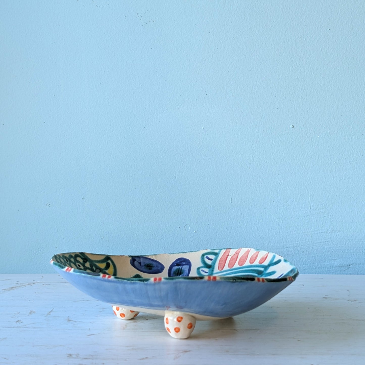 Ceramic bowl with colorful design on a light blue background