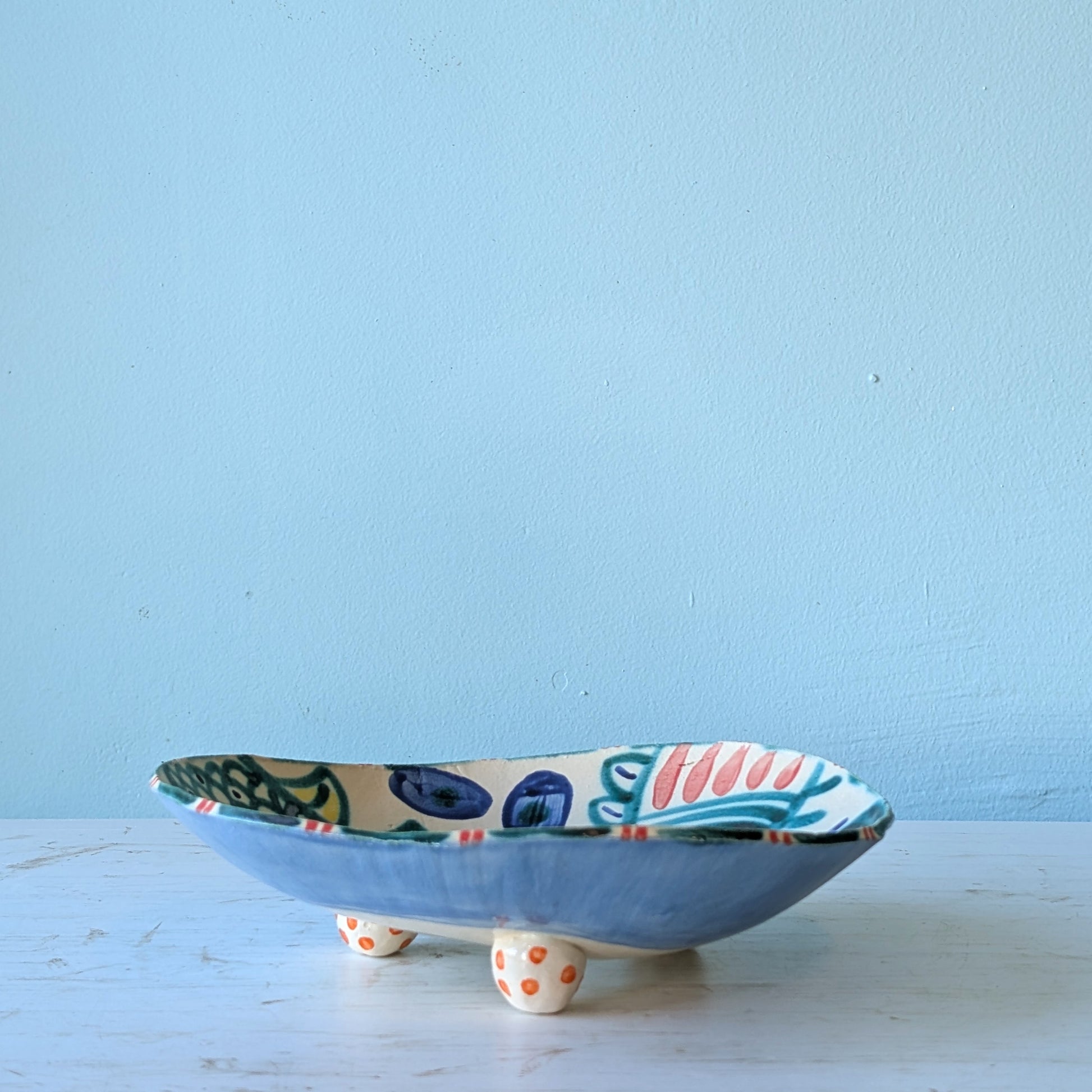 Ceramic bowl with colorful design on a light blue background