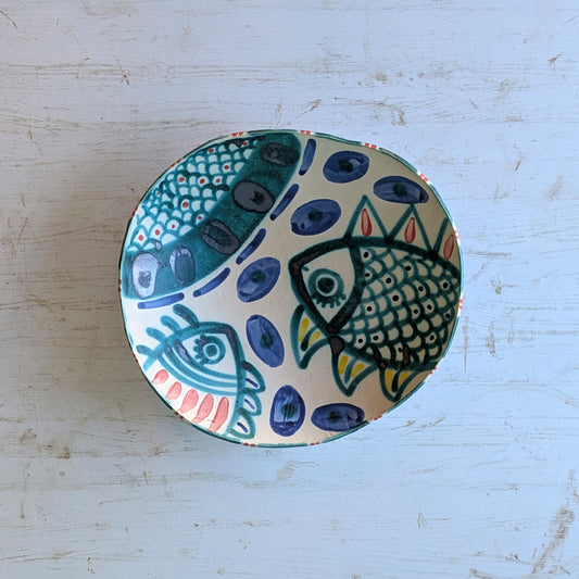 Ceramic plate with fish designs on a light blue surface