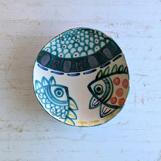 Ceramic bowl with fish design on a light blue background