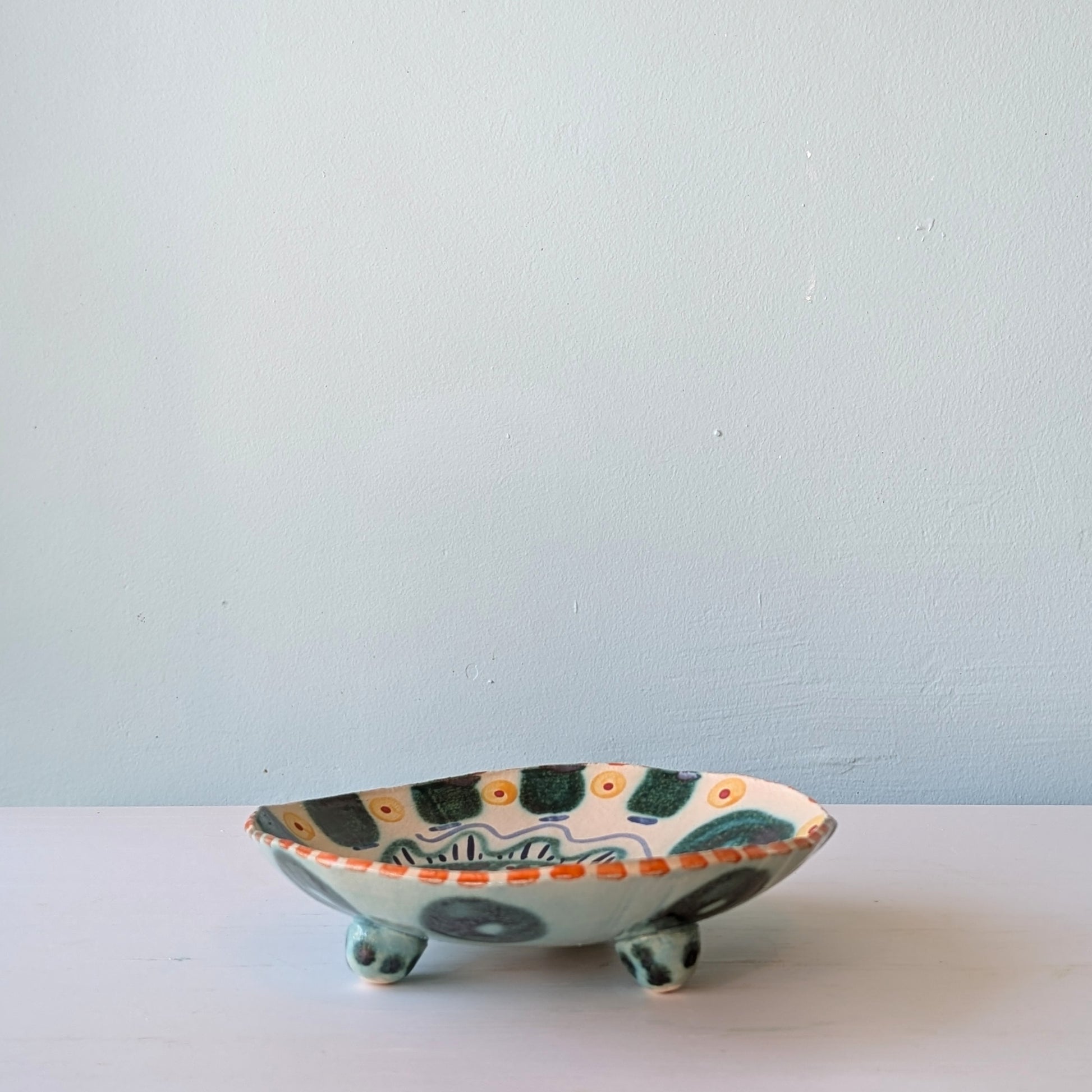 Ceramic bowl with decorative patterns on a white surface and light blue background