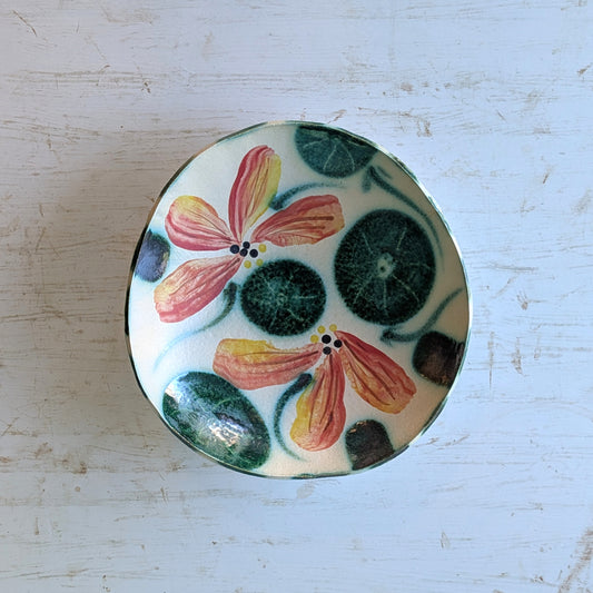 Ceramic bowl with multicoloured floral pattern on a white table