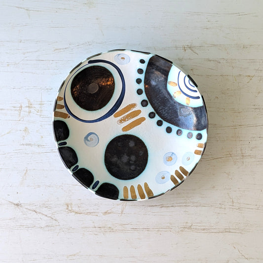 Ceramic bowl with abstract design on a light wooden surface