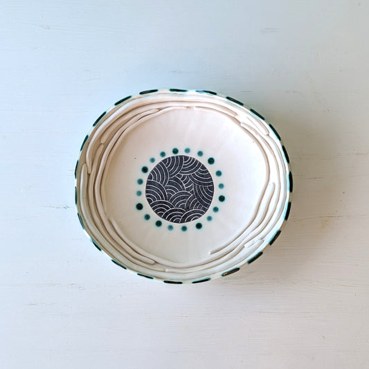 Ceramic bowl with decorative patterns on a light wooden surface