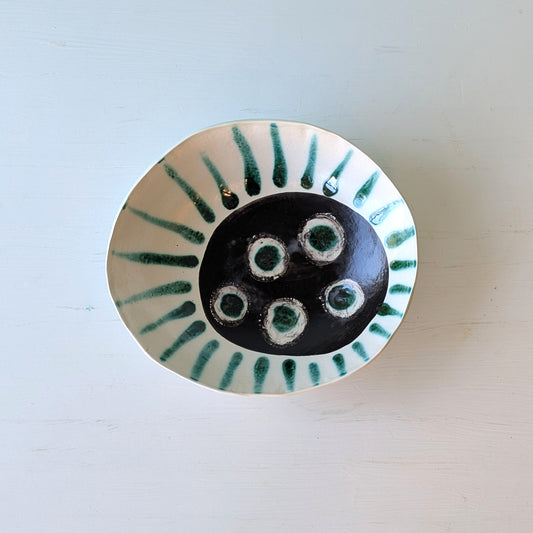 Ceramic bowl with green abstract design on a white background